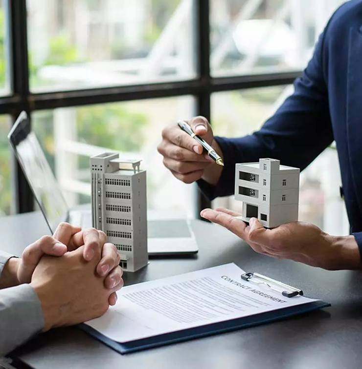 Reunión de negocios inmobiliarios con documentos y modelos de casas